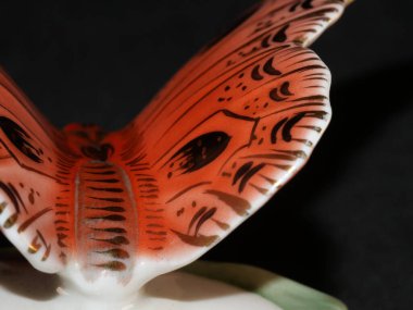 Porselen kelebek figürü siyah arka planda izole edilmiş.