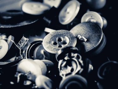 Düğmelerin gri tonlu fotoğrafı. Çeşitli yedek kıyafet düğmeleri koleksiyonu. Makro. DOF