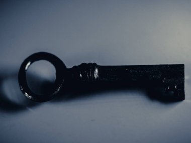 Altın anahtarın gri tonlu fotoğrafı beyaz arkaplanda izole edilmiş. Eski paslı kapı anahtarı. Antika altın anahtar. Metal gümüş anahtar. Seçici odak.
