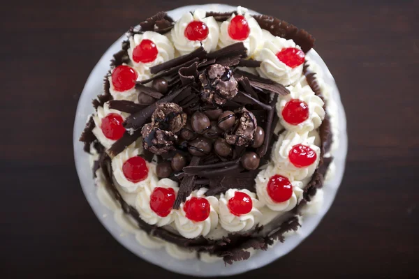 Pastel de chocolate con crema y cerezas . — Foto de Stock