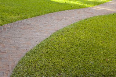 eğri kırmızı tuğla geçit yeşil çim ile