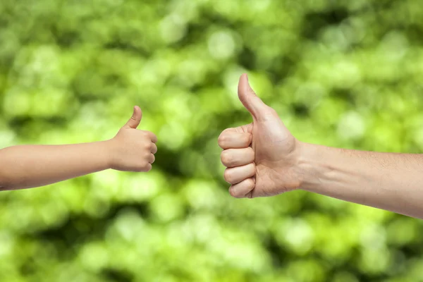 Father and son hands giving like on nature background — Stock Photo, Image