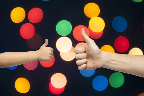 Padre e hijo manos dando como en Navidad luces fondo — Foto de Stock