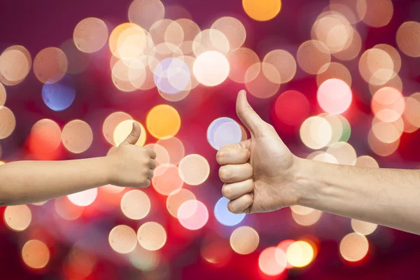 Father and son hands giving like on christmas lights background — Stock Photo, Image