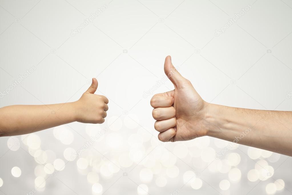 Father and son hands giving like on christmas lights background