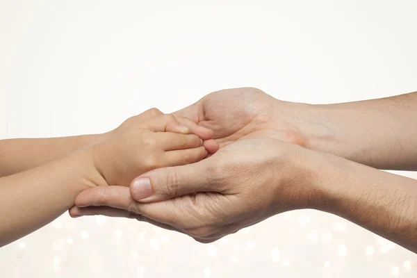 Far och son hand i hand på jul ljus bakgrund. — Stockfoto