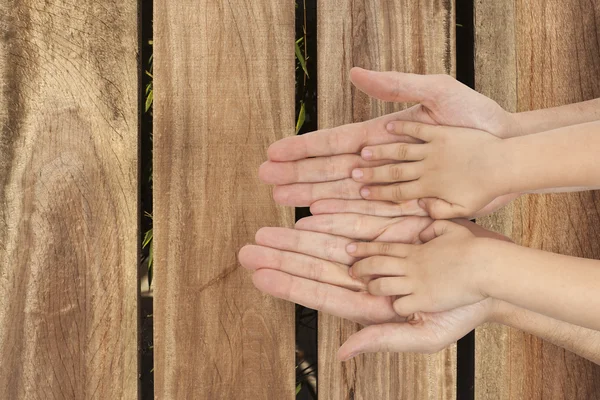 Father and son holding hands on wooden background — Stock Photo, Image