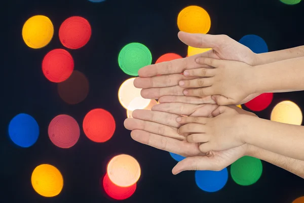 Far och son hand i hand på jul ljus bakgrund. — Stockfoto