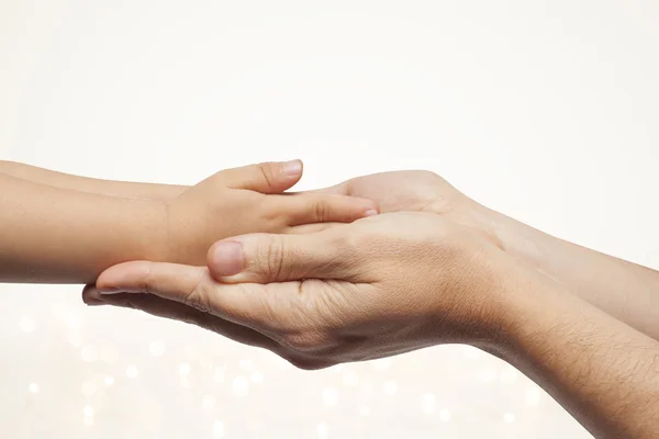 Father and son holding hands on christmas lights background. — Stock Photo, Image