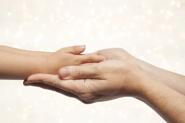 Padre e figlio che si tengono per mano su sfondo luci di Natale . — Foto Stock