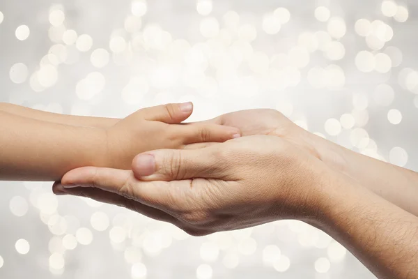 Vater und Sohn halten Hand an Weihnachtsbeleuchtung. — Stockfoto