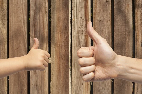 Father and son hands giving like on wooden background. — Stock Photo, Image