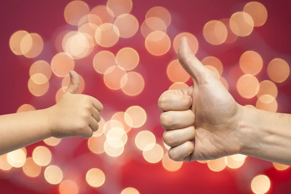 Father and son hands giving like on christmas lights background — Stock Photo, Image