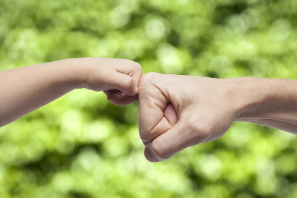 Father and son punching fists for agreement on natural background. — Stock Photo, Image