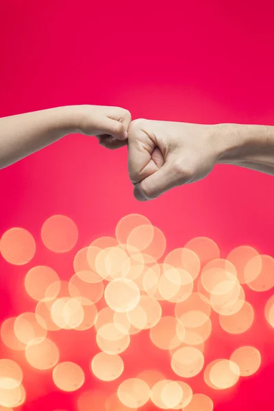 Father and son punching fists for agreement on christmas lights background. — Stock Photo, Image