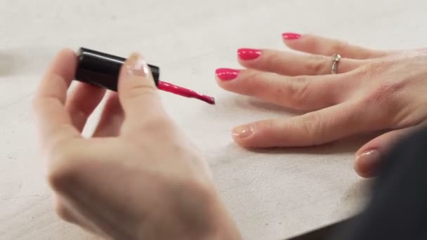 Una giovane ragazza europea si dipinge le unghie con smalto rosa — Video Stock