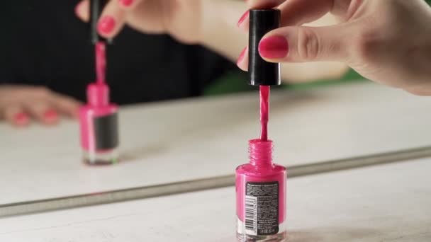 Una joven europea se pinta las uñas con esmalte de uñas rosa — Vídeos de Stock