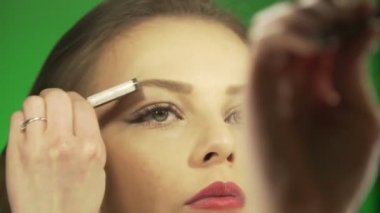 Genç Avrupalı bir kız evde makyaj yapıyor.