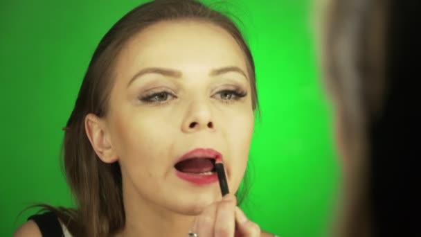 Joven mujer europea pinta los labios con lápiz labial rojo — Vídeos de Stock