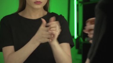 Genç bir Avrupalı kız aynanın önünde ellerine krem sürüyor.