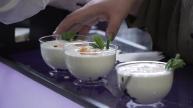 Süslü dondurma parçaları barın üstünde fincanların içinde.