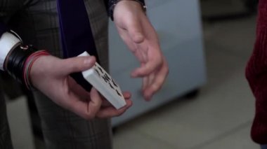 Kağıt oynayarak hile yapan takım elbiseli bir sihirbazın elleri.