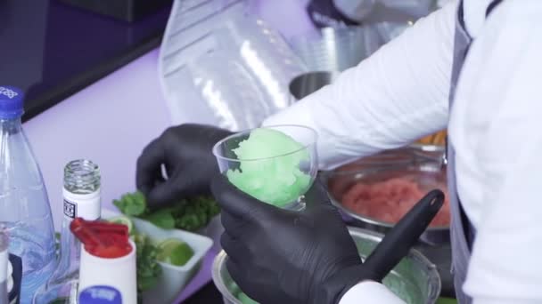 Руки бармена, який розкладає зелене фісташкове морозиво для гостей — стокове відео