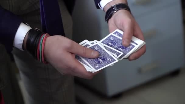 Ruce kouzelníka v obleku, který ukazuje triky s hracími kartami — Stock video