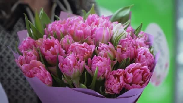 Menina segurando um buquê de flores rosa no feriado — Vídeo de Stock