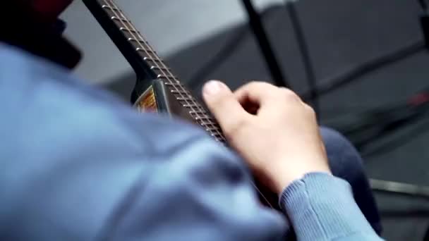 Un hombre de una orquesta de teatro con una chaqueta azul sostiene un balalaika en un ensayo — Vídeo de stock