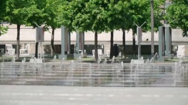  Yazlık elbiseli bir kız çeşmelerin önünden geçiyor.