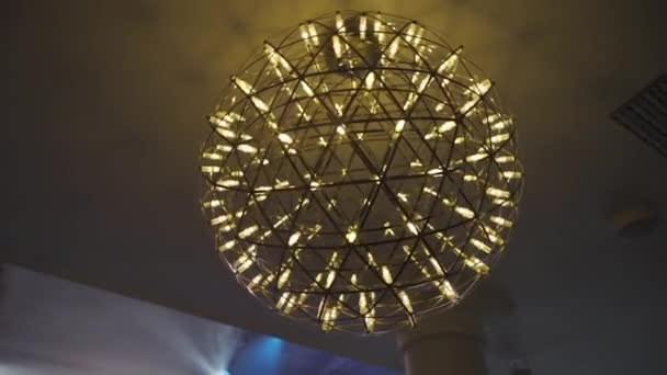 Egy szokatlan labda alakú csillár egy koncertteremben — Stock videók