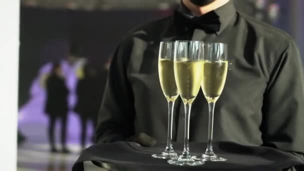 Официант в черной ленте несет шампанское — стоковое видео