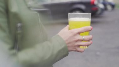 Genç Avrupalı kız bardaktan soda içiyor.