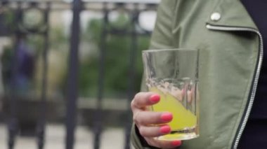 Genç Avrupalı kız elinde bir bardak soda tutuyor.