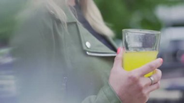 Genç Avrupalı kız elinde bir bardak soda tutuyor.