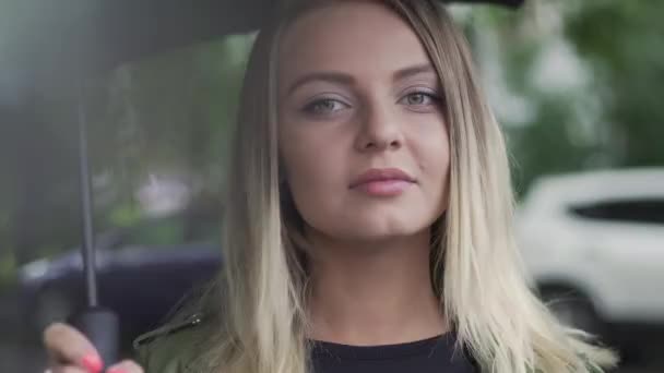 Молодая европейская девушка стоит с черным зонтиком — стоковое видео