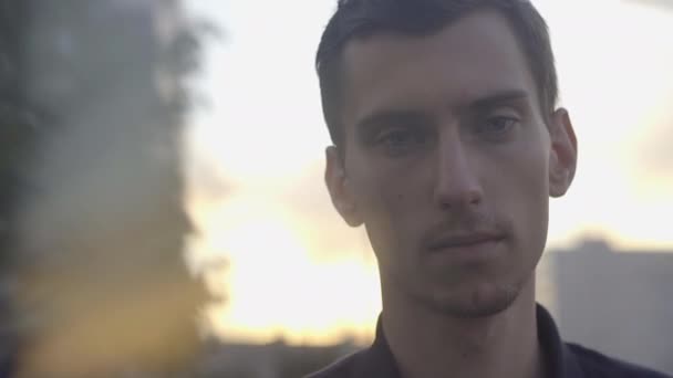 Seorang pria muda kurus berdiri saat matahari terbenam — Stok Video