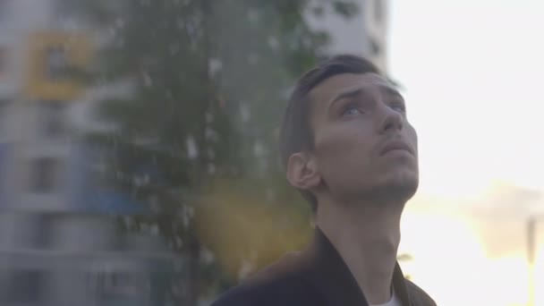 Худенький молодой парень стоит на закате — стоковое видео