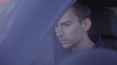 Genç, sıska bir Avrupalı sürücü koltuğunda oturuyor.