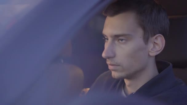 Egy fiatal vézna európai fickó ül a vezetőülésen — Stock videók