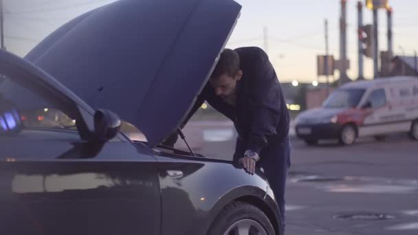 Jovem magro europeu cara fixando seu carro — Vídeo de Stock