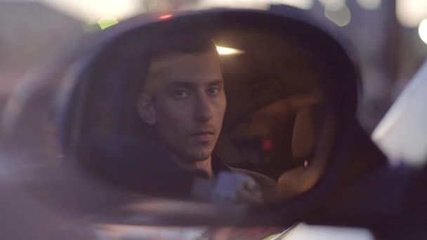 Молодой тощий европеец садится за руль — стоковое видео