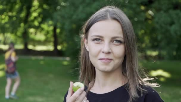 Niña comiendo una manzana en el bosque de verano — Vídeos de Stock