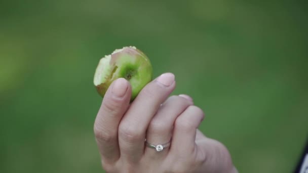 Une pomme mordue dans la main d'une jeune fille caucasienne — Video