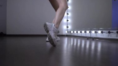 Stüdyoda ayna karşısında dans provası yapan genç bir kızın ayakları..