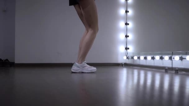 Ноги молодой девушки, репетирующей танец в студии перед зеркалом. — стоковое видео