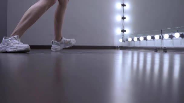 Pieds d'une jeune fille répétant une danse dans le studio devant le miroir. — Video