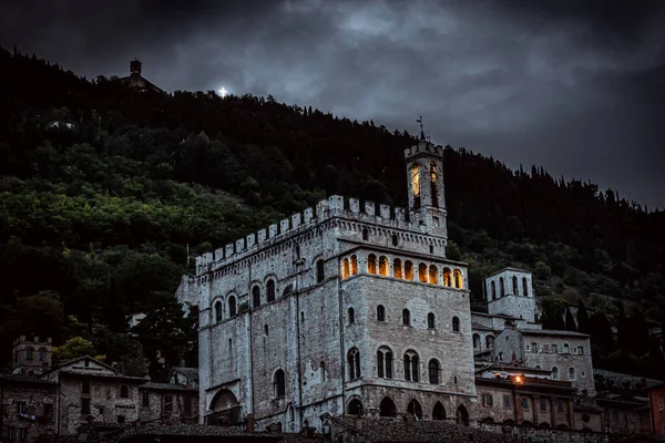 Vista nocturna en edificio iluminado y cruz en la montaña en Gubbio —  Fotos de Stock