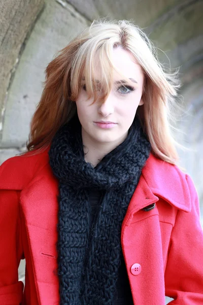 Beautiful young woman with blonde hair wearing red jacket
